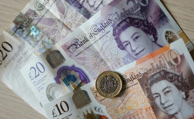 Một bức ảnh tập tin được chụp vào ngày 22 tháng 4 năm 2022 cho thấy những tờ tiền và tiền xu bằng bảng Anh được bày trên một chiếc bàn ở London.  Tiền giấy cuối cùng sẽ thay đổi sau cái chết của Nữ hoàng Elizabeth II.